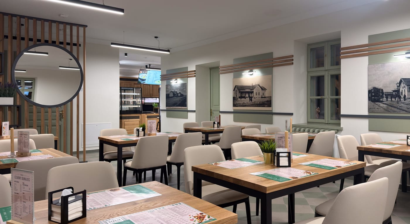 Wnętrze restauracji z archiwalnymi zdjęciami dawnej stacji kolejowej na ścianach